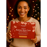 Woman holding a red box of gymsegbe Korean Skin Care collection with festive lights in the background