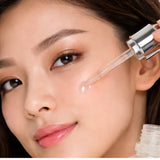 Woman applying a dropper of luminous mighty punch serum to her face