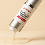 Gymsegbe Snail Mucin 99 Power Bomb Essence bottle with essence flowing out on a beige background