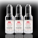 Three bottles of Dynamite Vitamin Serum on a reflective surface with a gradient background.