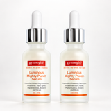Two identical bottles of gymseg·b¹ Luminous Mighty Punch Serum on a clean white background. The bottles are frosted glass with white droppers, silver caps, and red and orange labels.