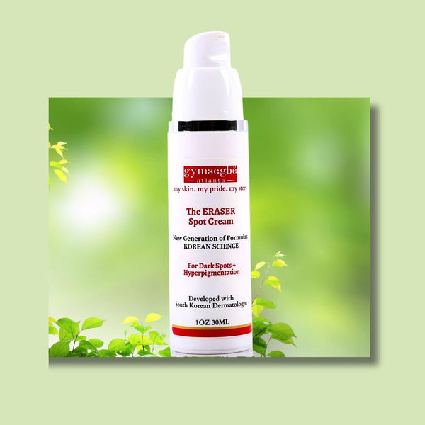 A pump bottle of Gymsegbe's The Eraser Spot Cream is placed against a blurred green background with leaves.