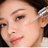 Woman applying a dropper of luminous mighty punch serum to her face