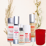 Collection of skincare products with a red pouch on a light background