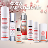 Set of skincare products with cherry blossoms in the background, labeled 'Glow Essentials Set'.