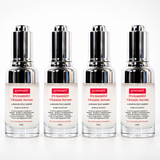Four identical bottles of gymsgb· Dynamite Vitamin Serum arranged in a row on a white background. Each bottle has a clear glass body, a silver pump dispenser, and a white label with a red gymsgb· logo and black text.