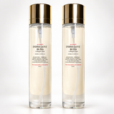 Two tall clear glass bottles of Indulgent Bliss Collagen Mist with shiny gold caps, standing side by side on a white background.