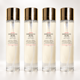 Four clear cylindrical bottles of Indulgent Bliss Collagen Skin serum arranged in a row on a white background, each with a reflective gold cap and a white label featuring red and black text.