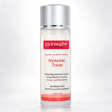 A 100ml bottle of gymsegbé Dynamic Toner on a light gray background. The bottle is clear with a white label featuring red and black text, and a metallic silver cap.