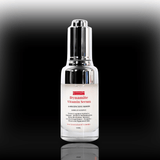 Skincare serum bottle labeled 'Dynamite Vitamin Serum' on a reflective black surface with a gradient background.